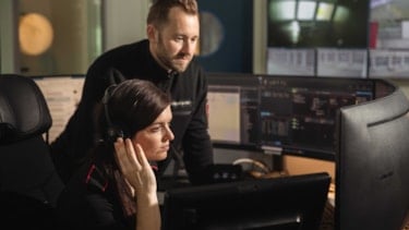 To alarmsentraloperatører ser på en skjerm