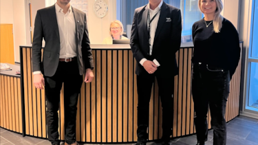 Bilde av tre smilende personer.