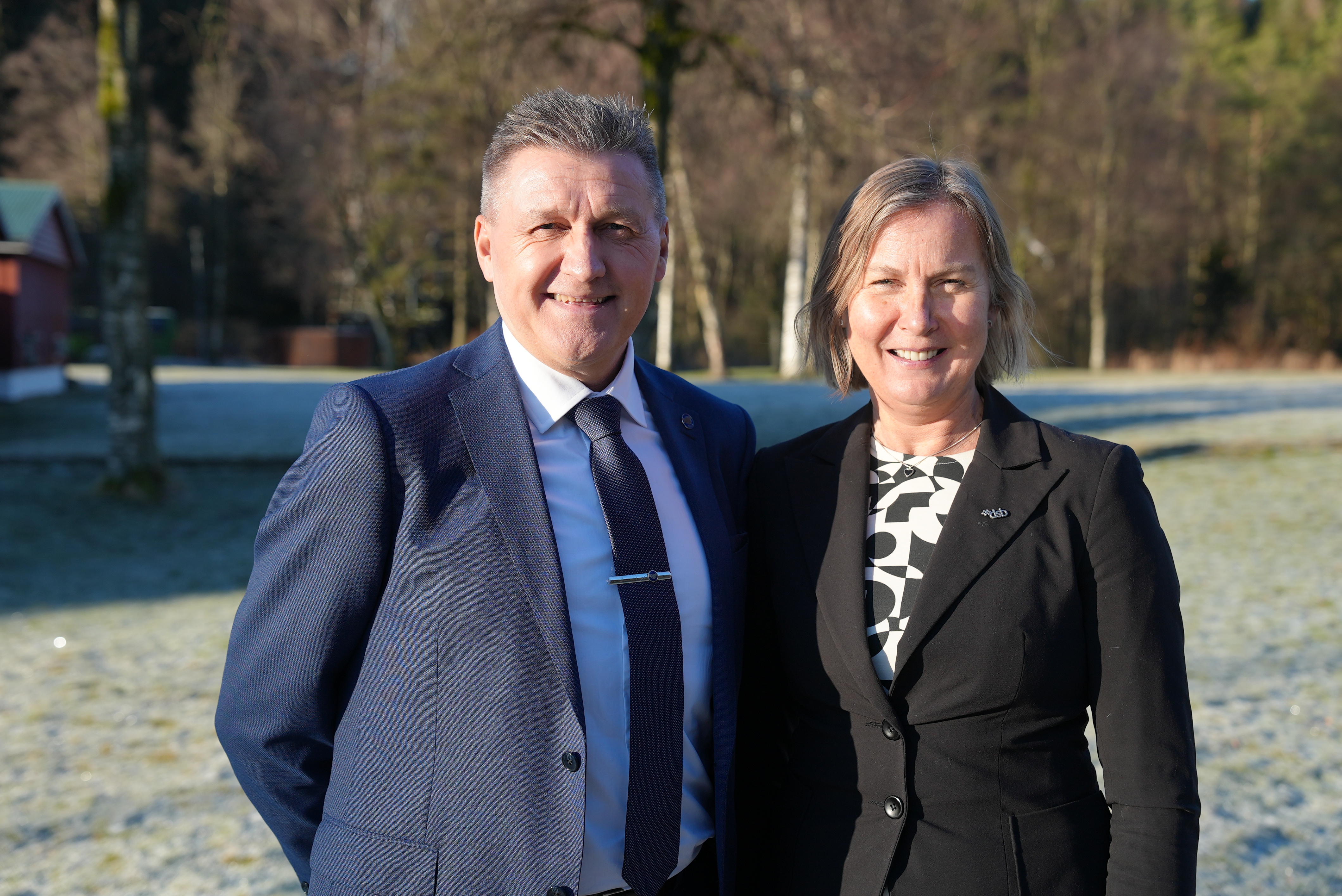 En dresskledd mann og kvinne smiler mot kamera