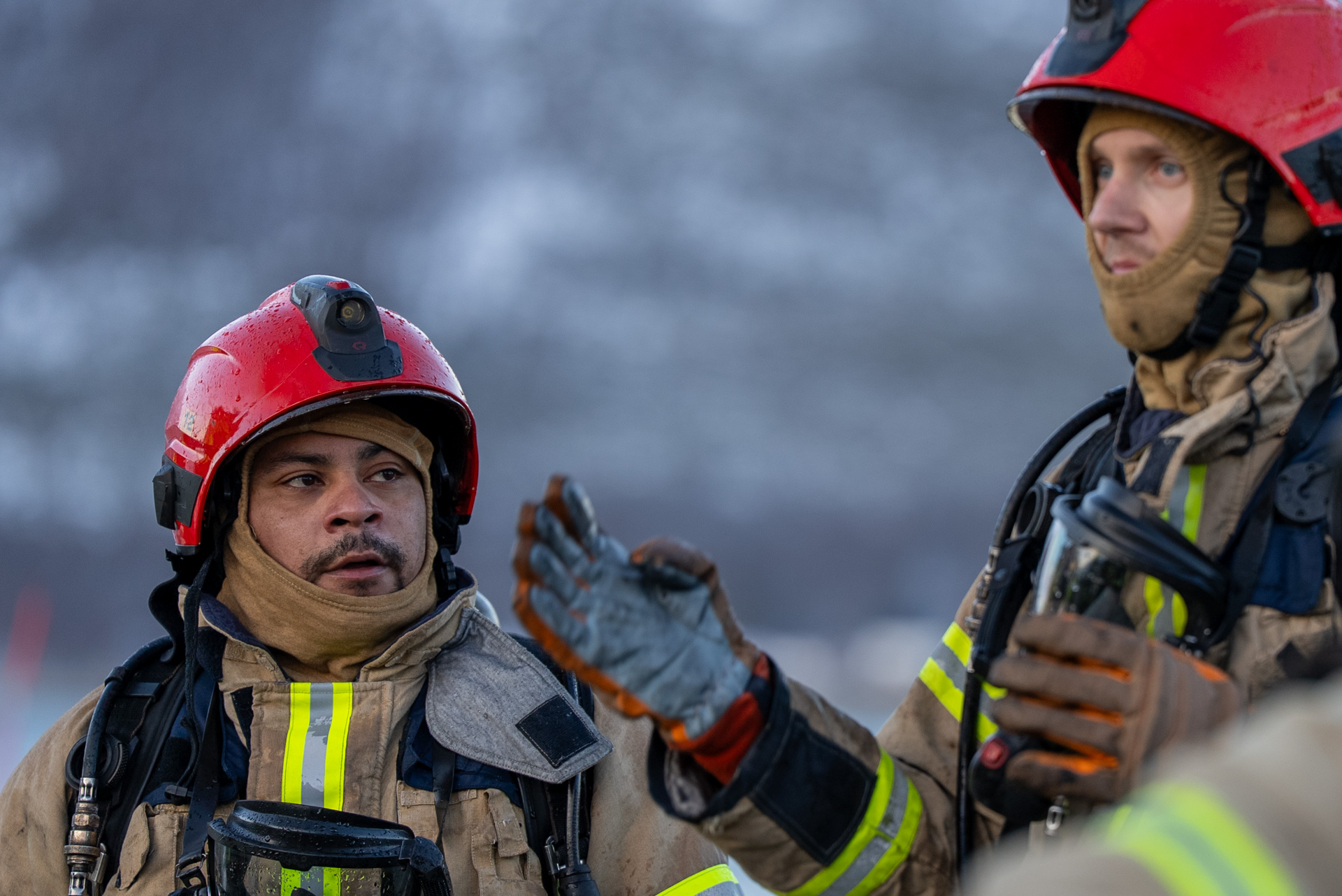 Nærbilde av to mannlige brannkonstabler, den ene er høyere enn den andre