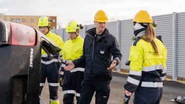 Undervisningssituasjon hvor deltakere har på seg trafikkdress og gul hjelm.