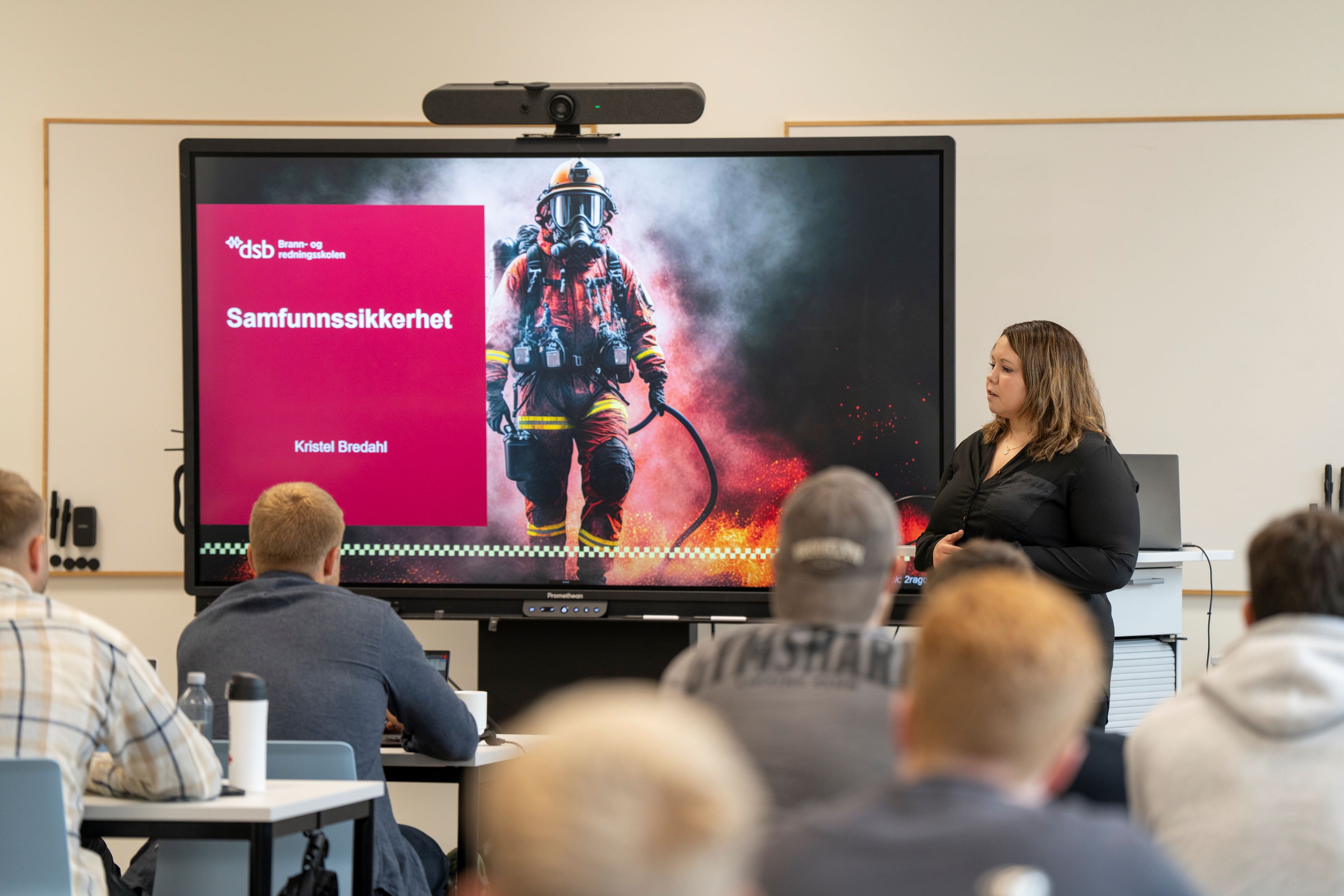 Kvinne stor foran en klasse og underviser. Foto