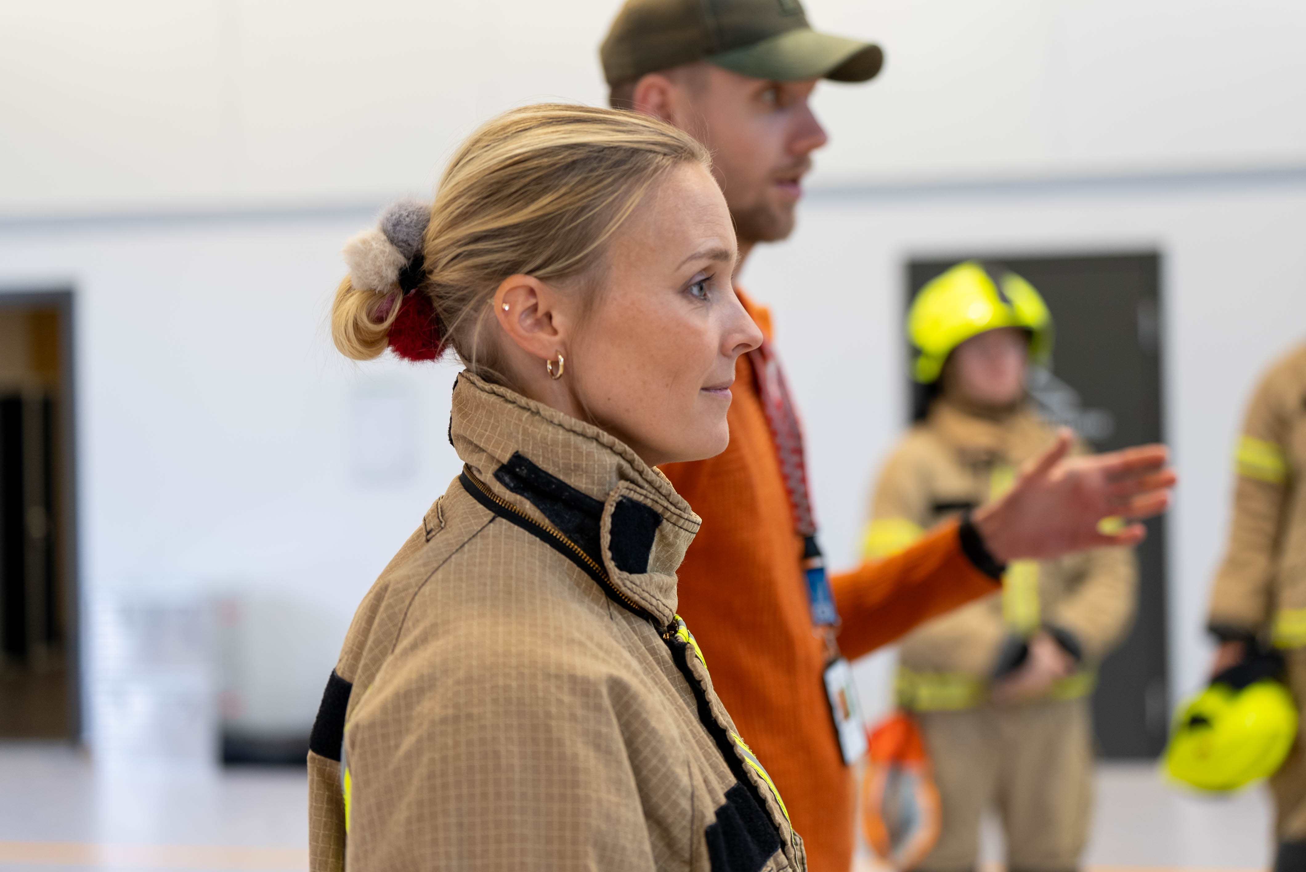 Nærbilde av en kvinne i røykdykkerdrakt, sett fra siden. 