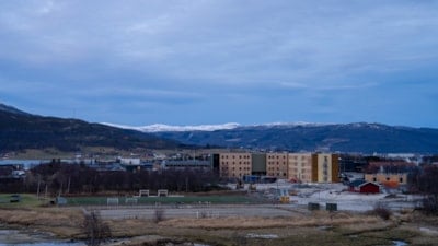 Et oversiktsbilde hvor man ser studentboliger i horisonten og fjell bak.