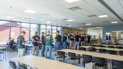 Studenter står i matkø i kantine