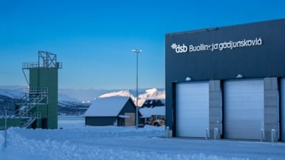 En brannstasjon, et lite hus og et vakttårn. Blå himmel bak.