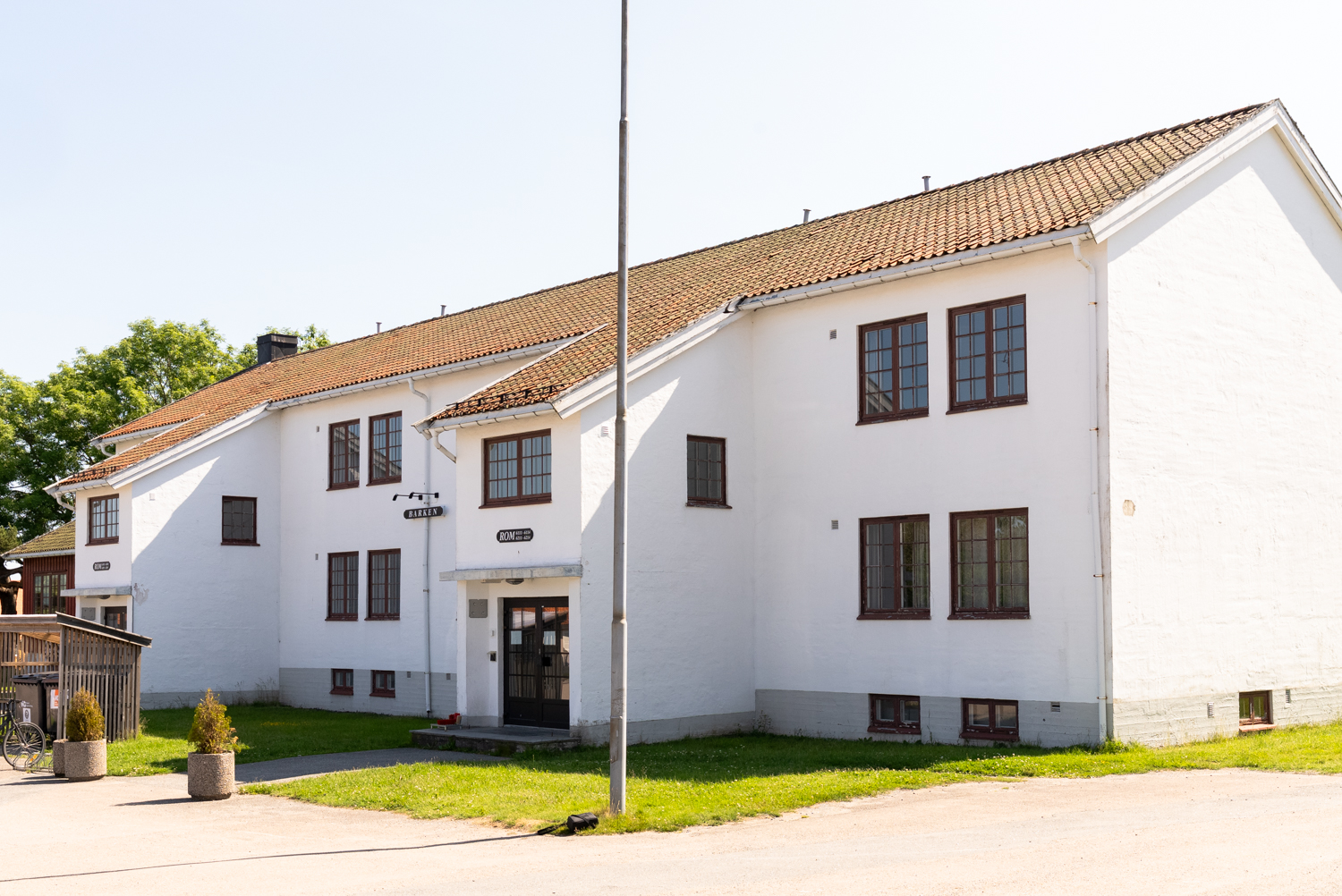 Et hvitt hus med mange vinduer sett fra siden