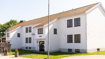 Et hvitt hus med mange vinduer sett fra siden