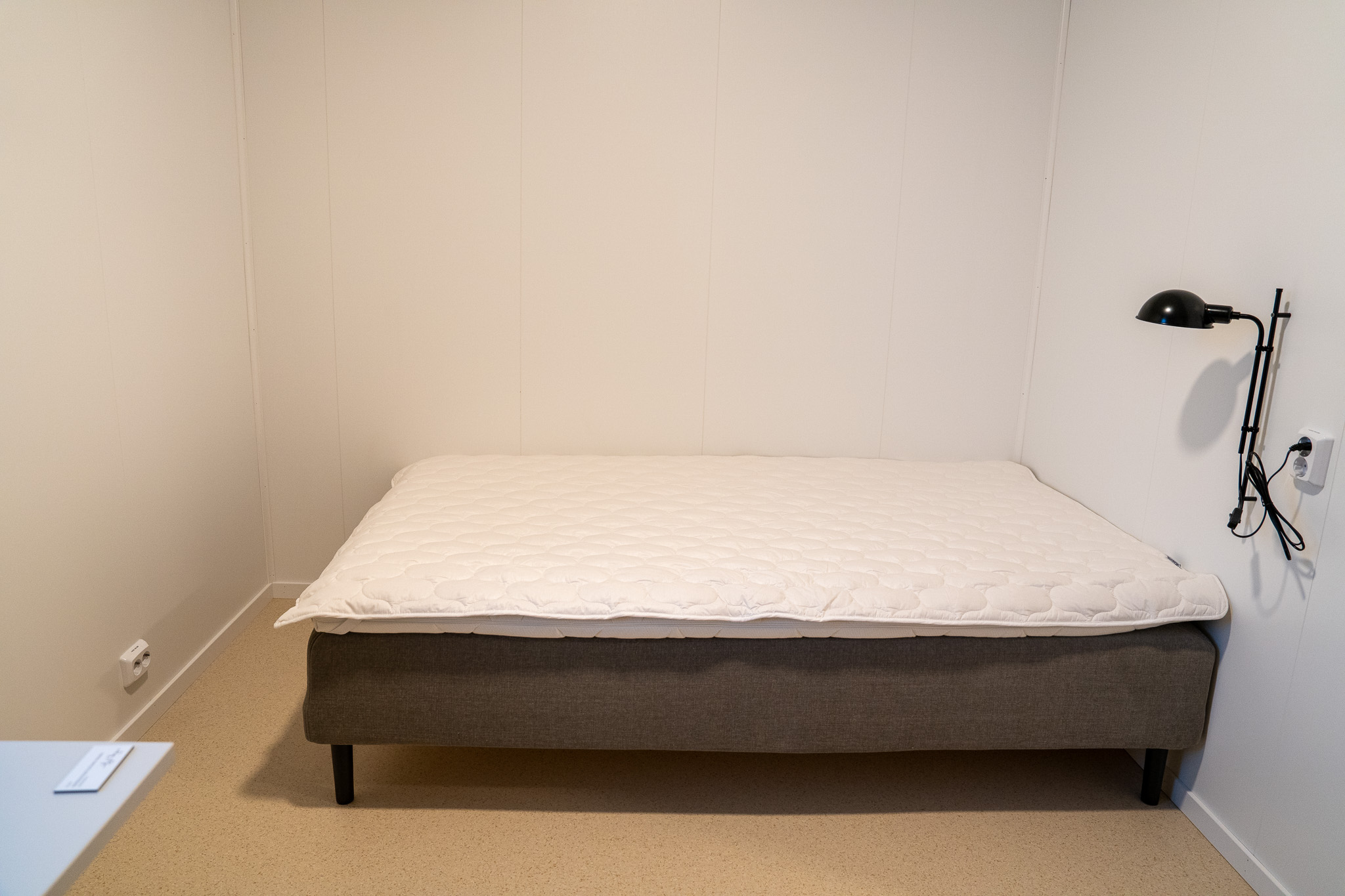 En seng med en leselampe over