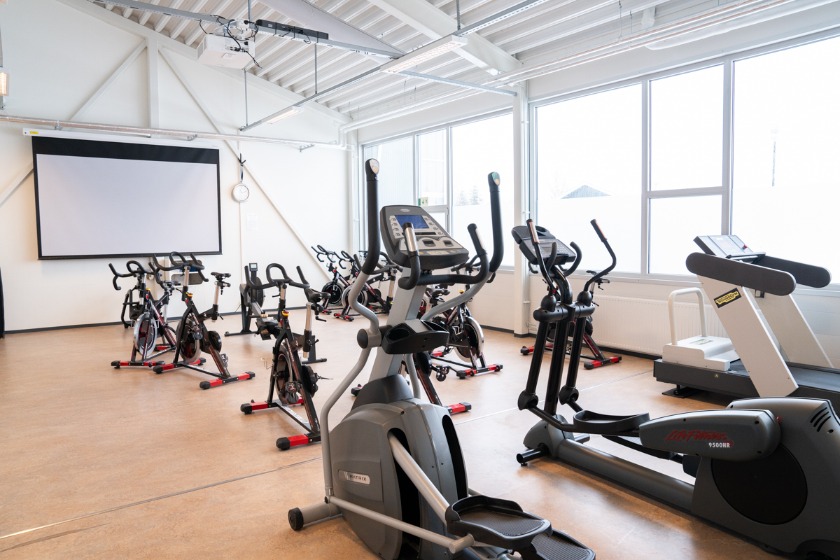 Tomme ergometersykler på rekke i et treningsstudio. Foto