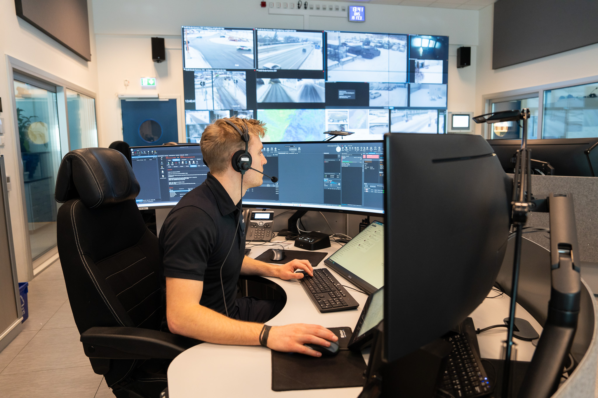 Mannlig operatør sitter foran skjermer på en 110-sentral