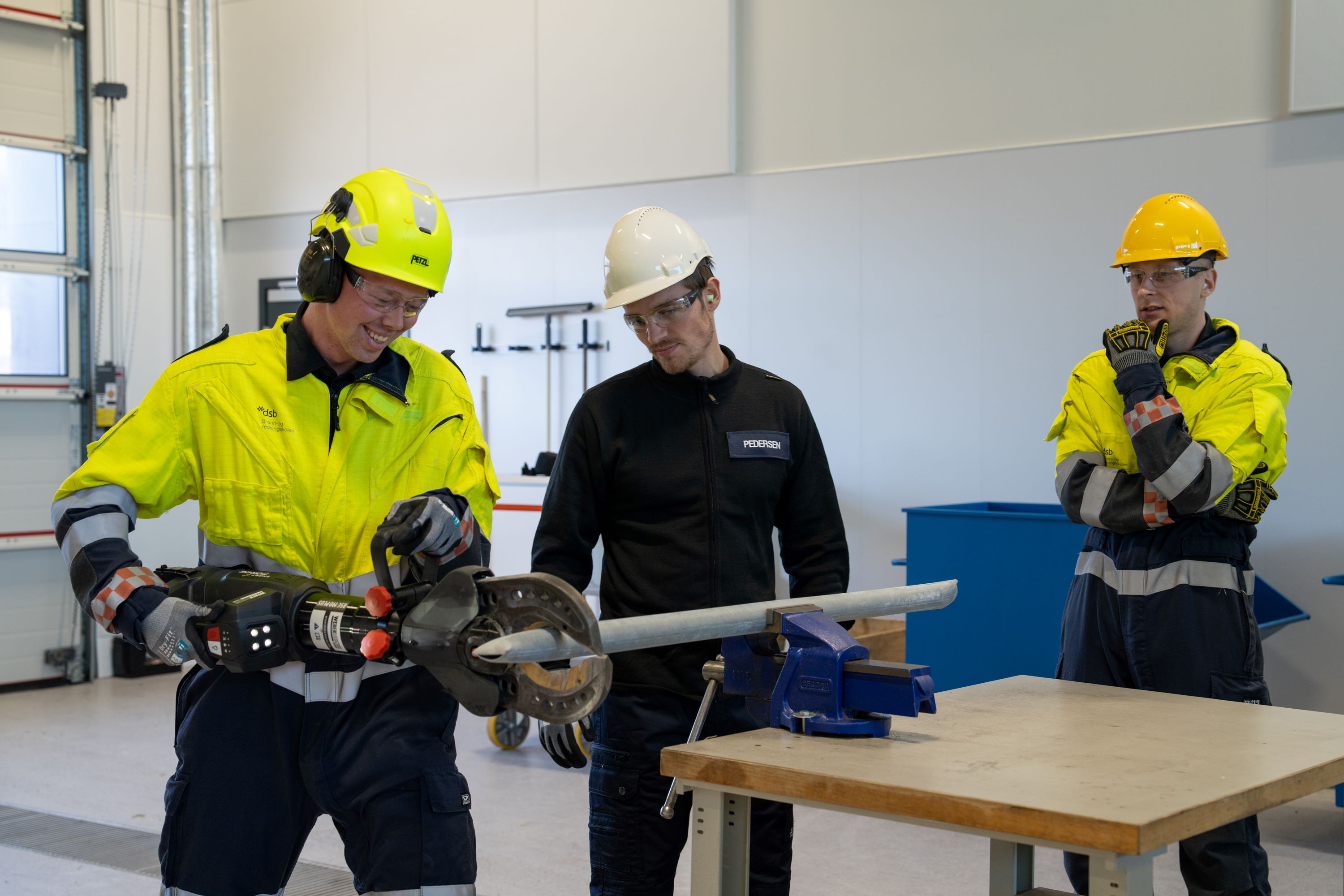 Mann som bruker et verktøy for å klippe en metallstang.