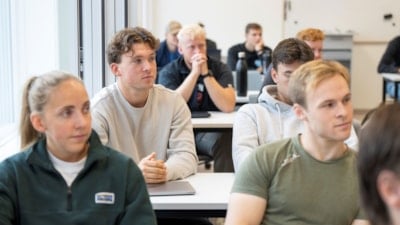 Studenter sitter ved pulter i undervisning