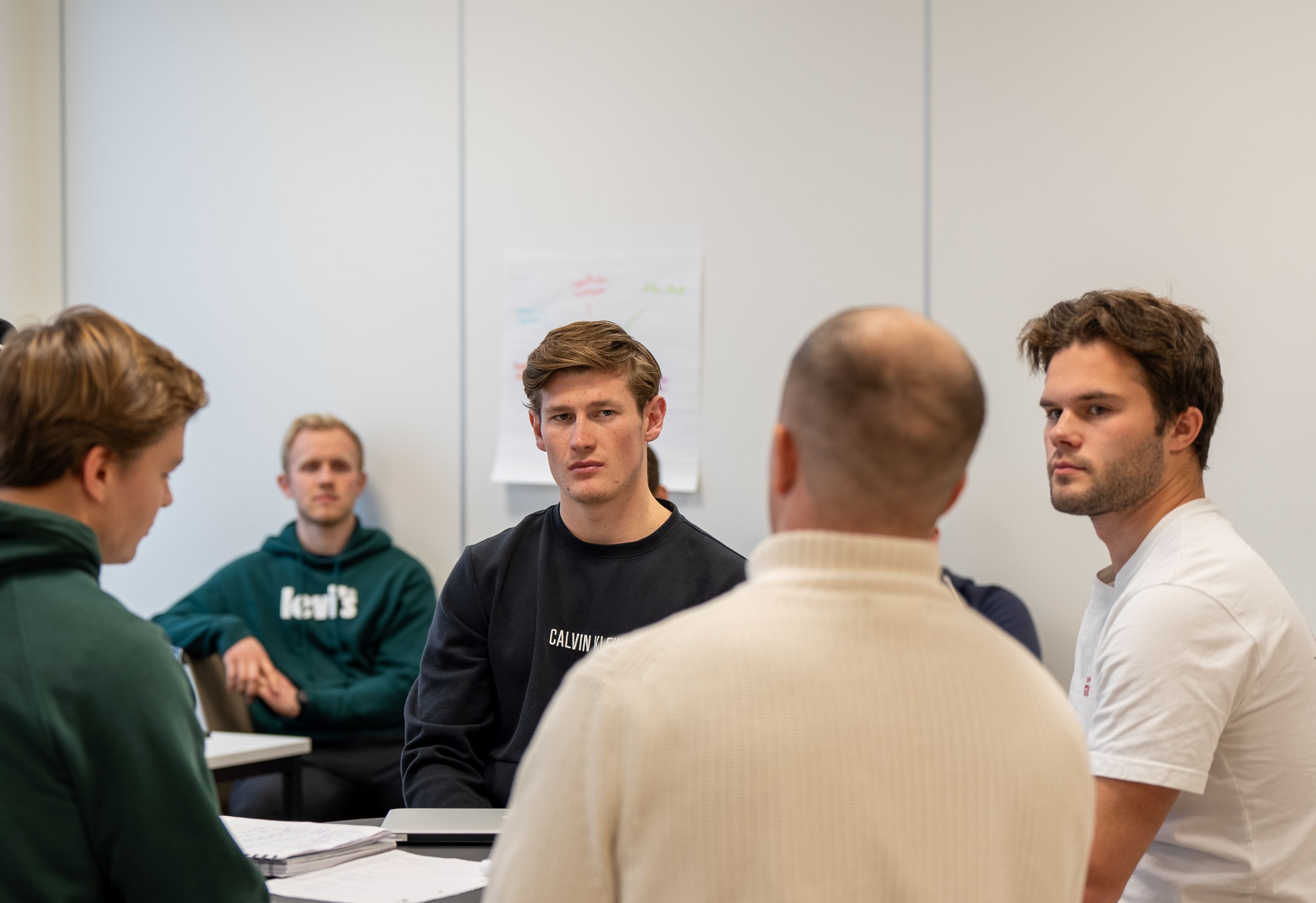 Fire menn sitter i en samtalegruppe