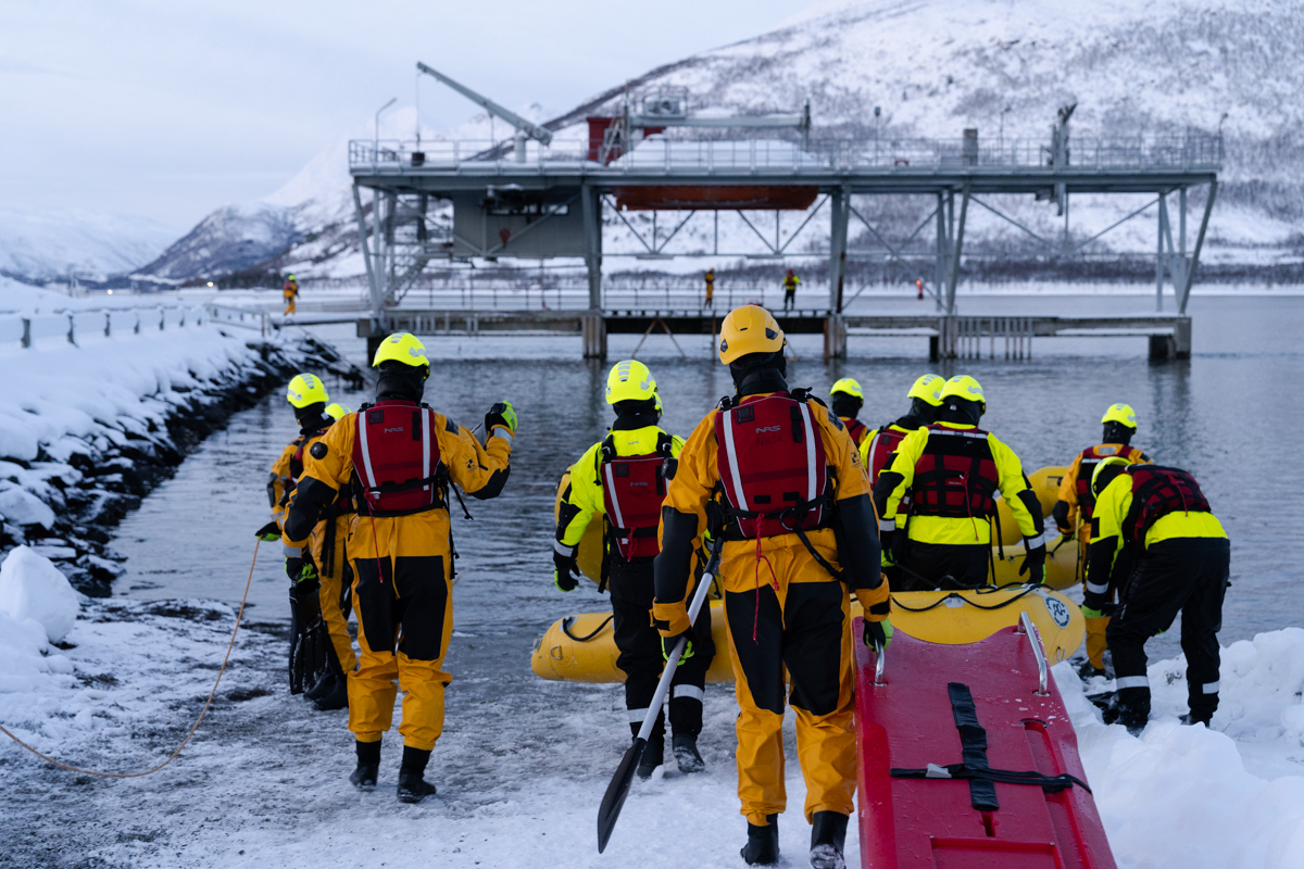 Flere studenter med ryggen til drar båre ut mot sjøen