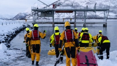 Flere studenter med ryggen til drar båre ut mot sjøen