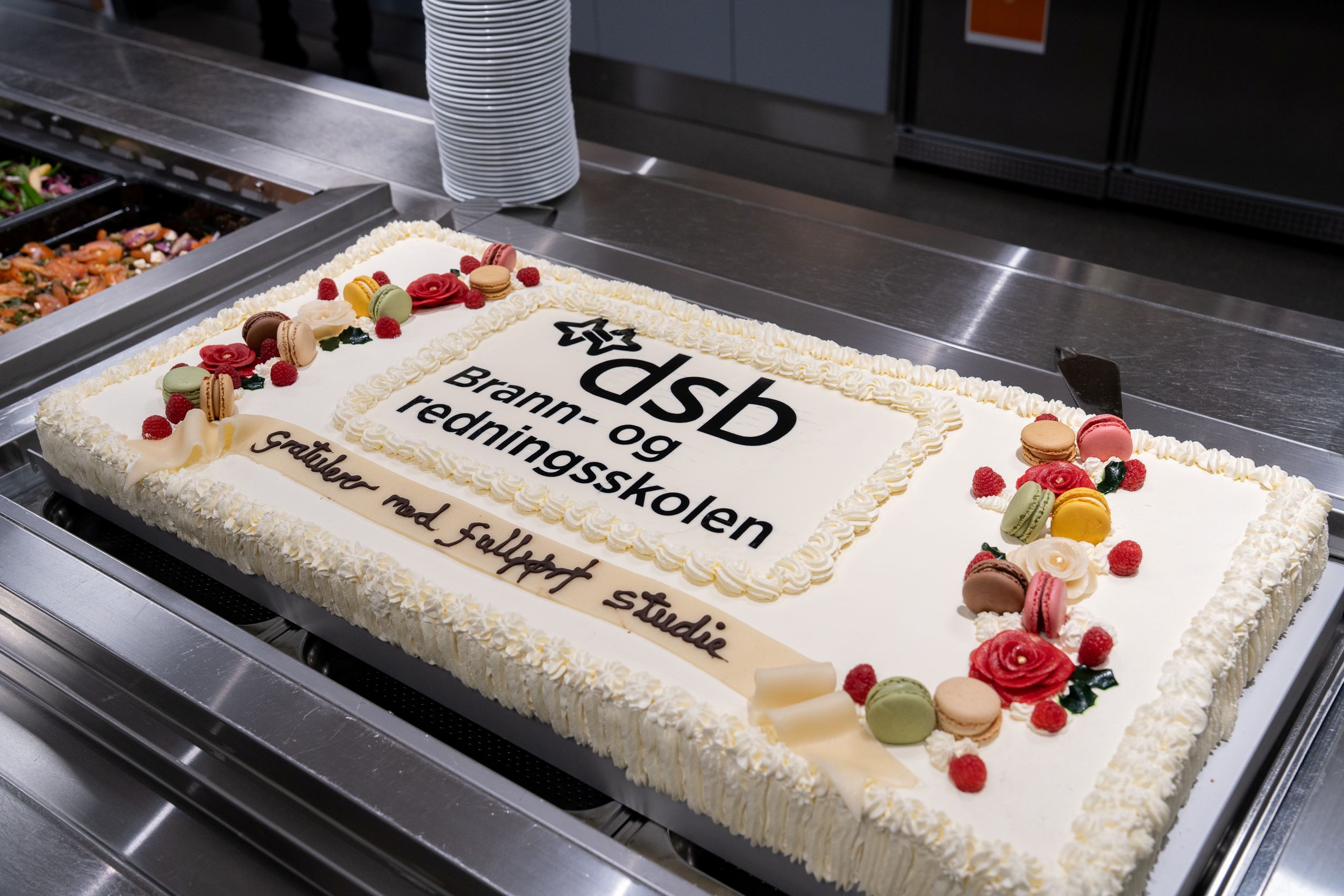 Nærbilde av en stor bløtkake med Brann- og redningsskolens logo