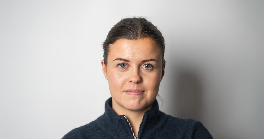 Ung kvinne ser vennlig inn i kameraet. Portrettbilde