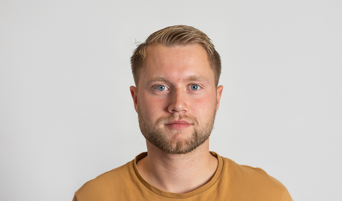 Ung mann ser inn i kamera. Portrettbilde