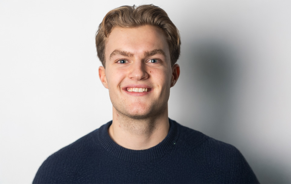 Ung mann med ser vennlig inn i kameraet