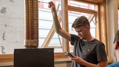 Elev måler temperaturen på røykgassen med et instrument