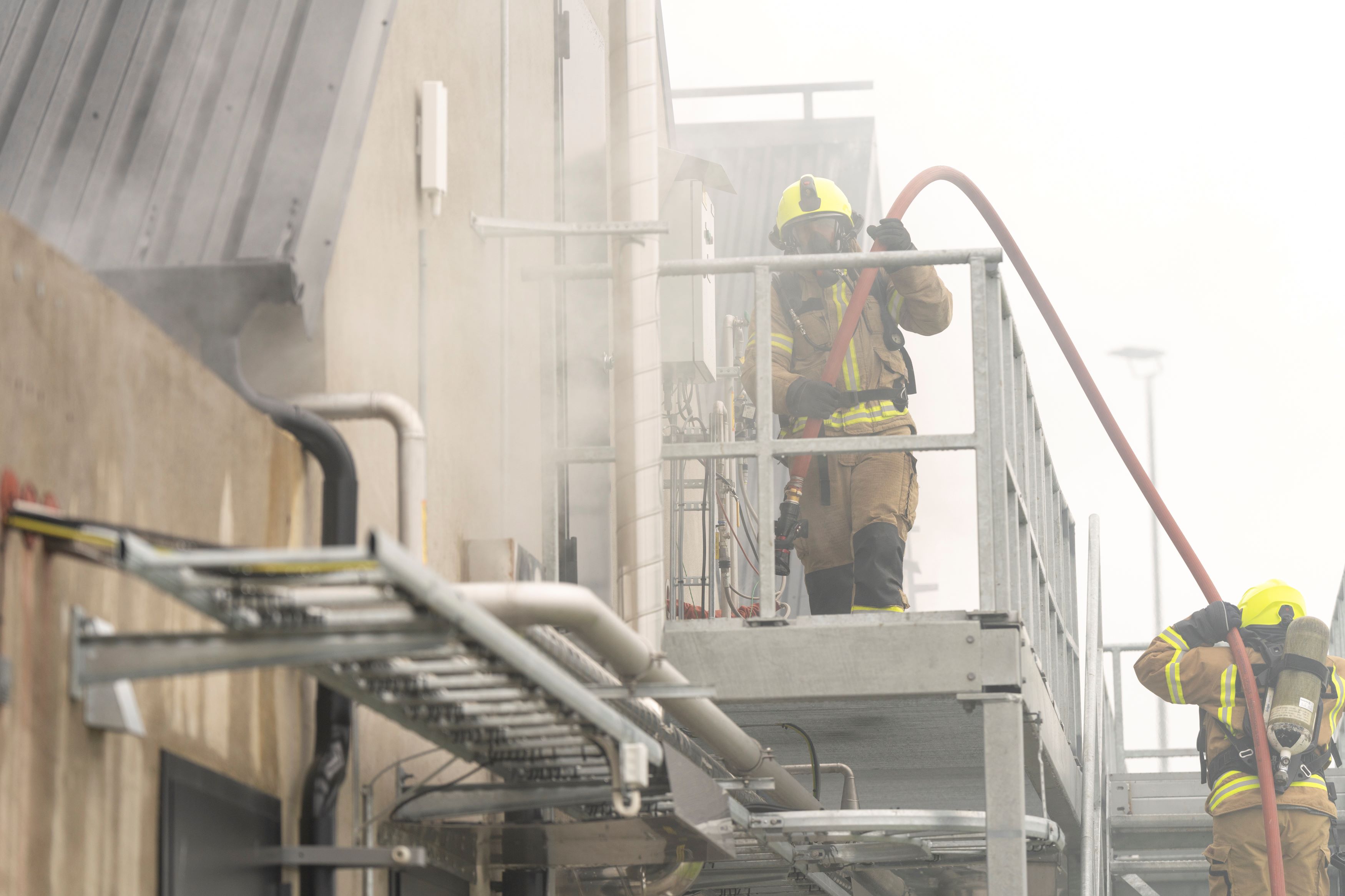 Brannkonstabler går inn i et bygg med røyk