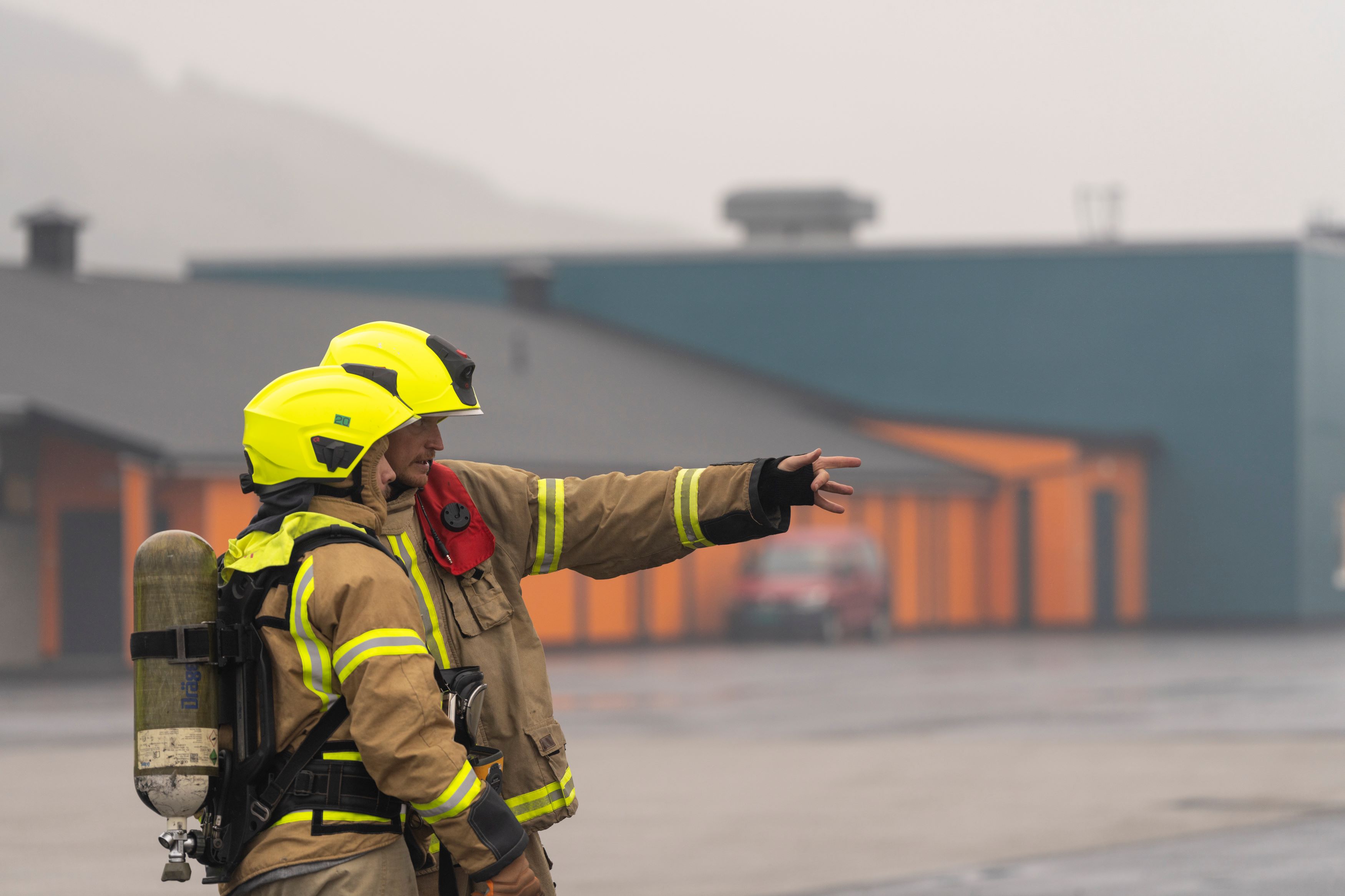 To brannkonstabler peker på noe bort fra kamera