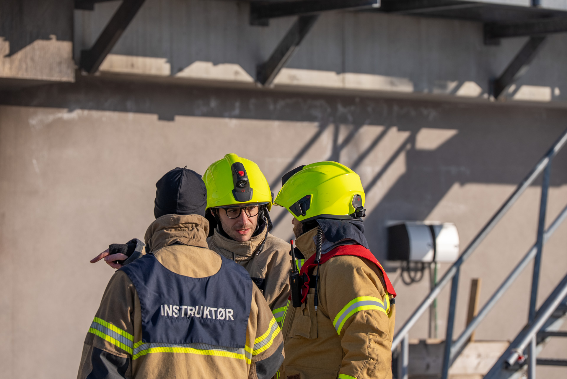 Tre brannkonstabler i samtale. Foto