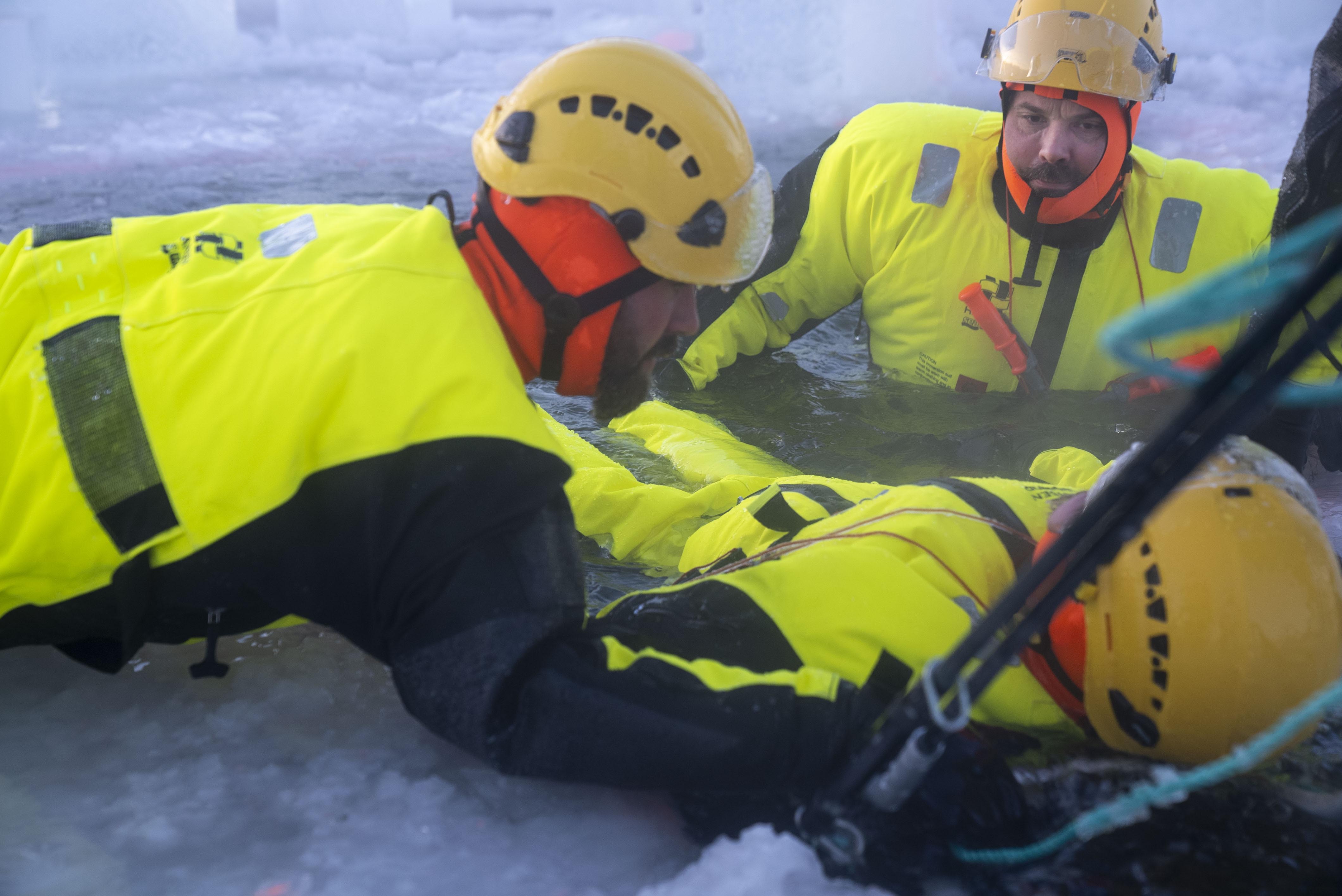 Person reddes opp av vannet på båre