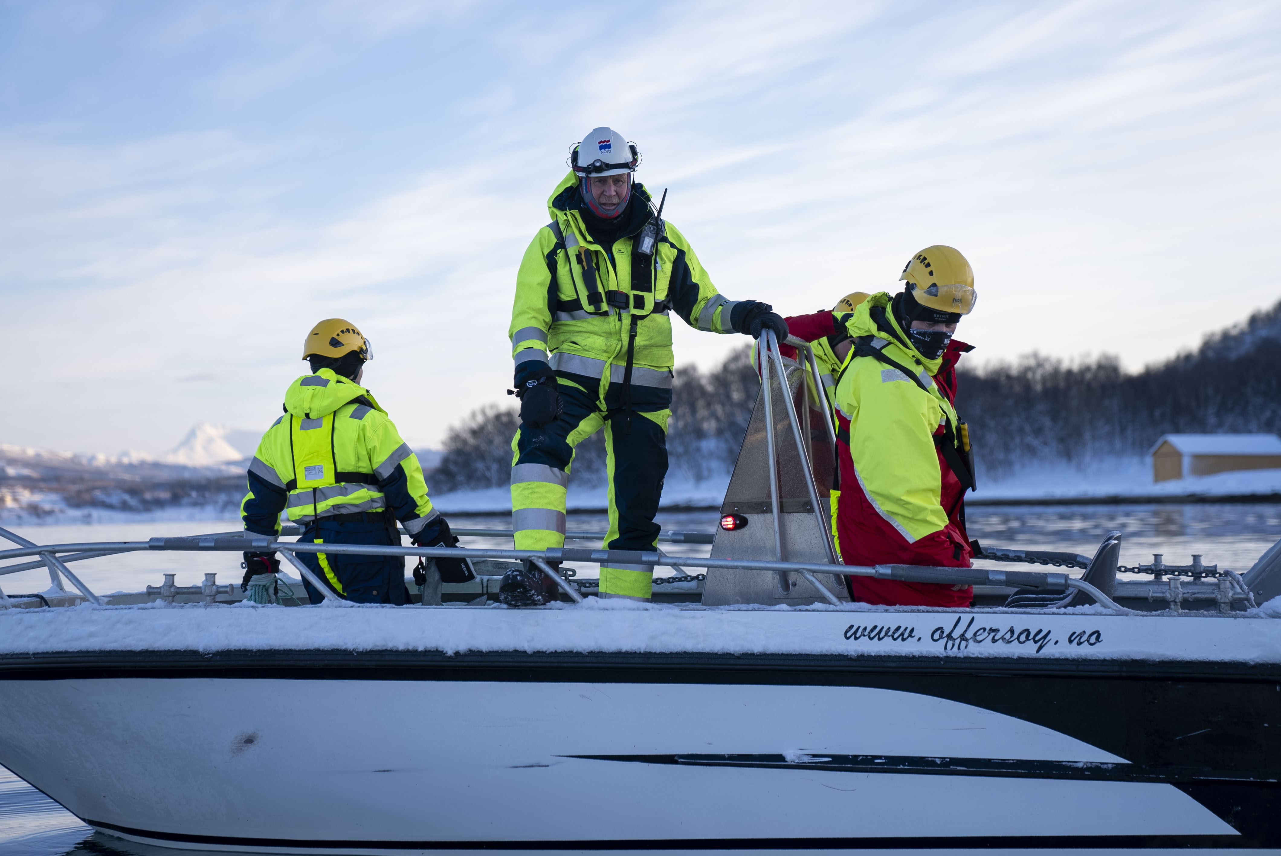 Tre menn i en båt skal koordinere innsats med lense