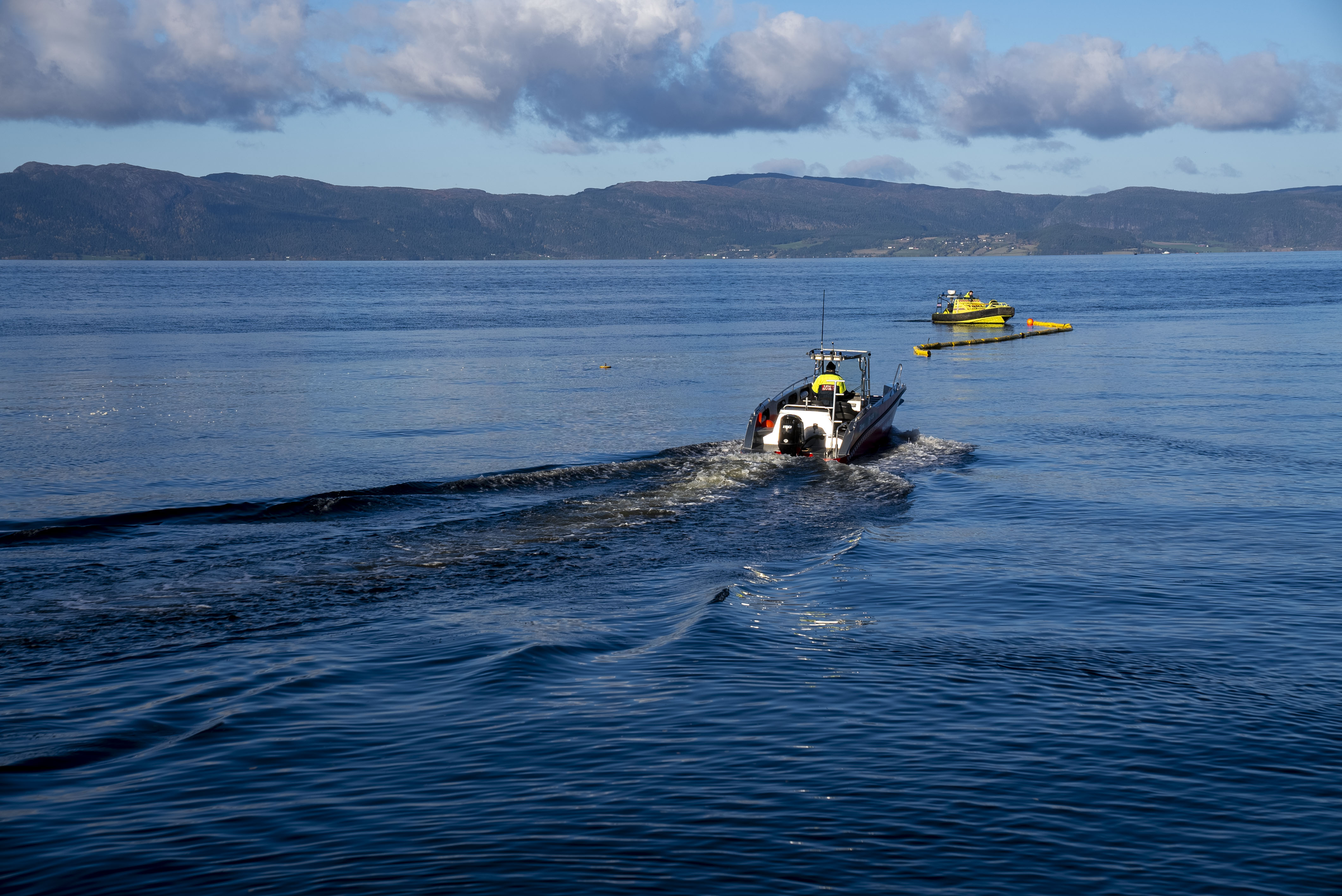 En båt kjører bort fra kamera med en lense som skal settes ut