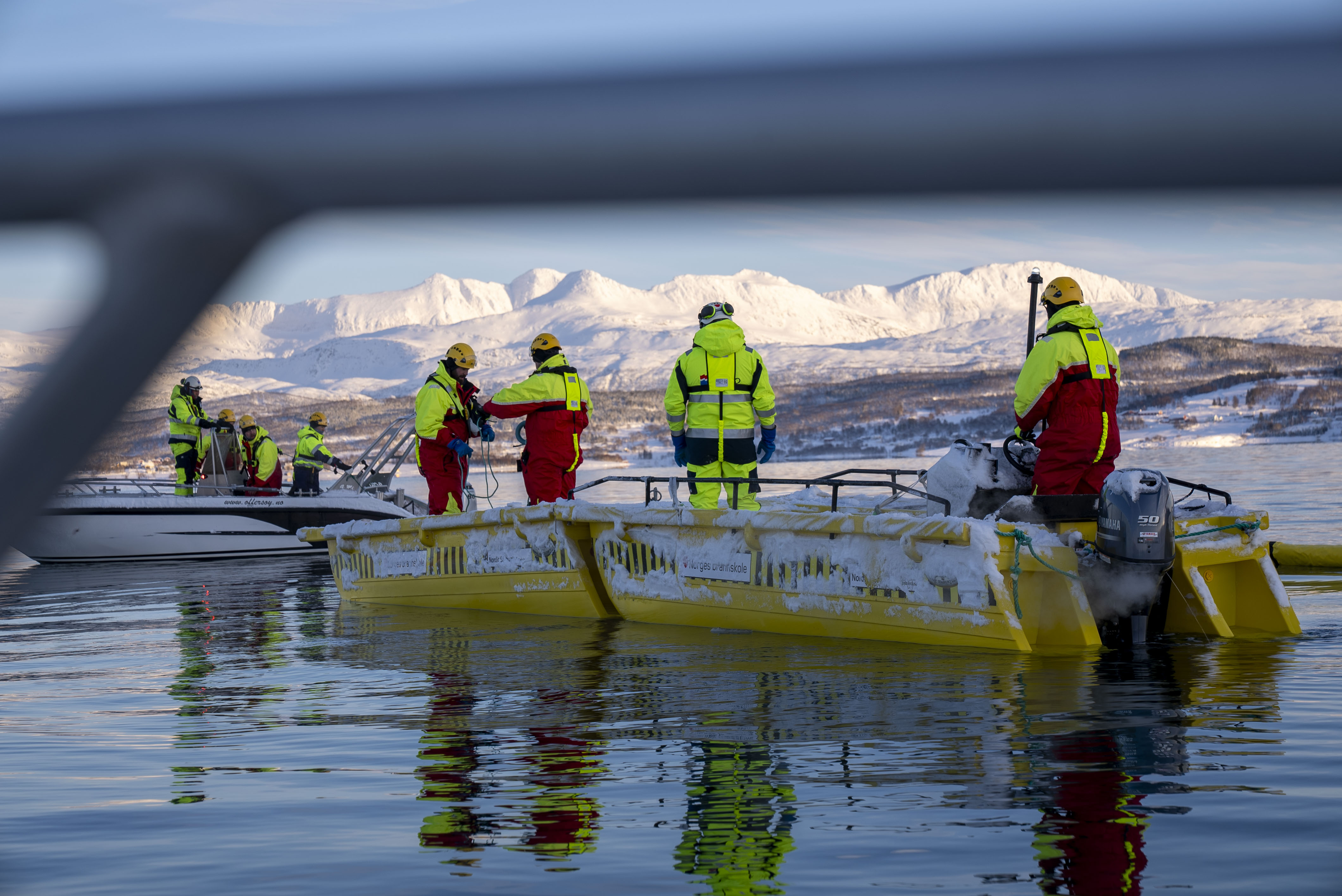 Flere menn i båt forankrer en lense