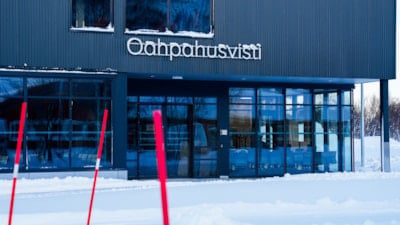 Et undervisningsbygg med samisk skilting. Snø foran. 